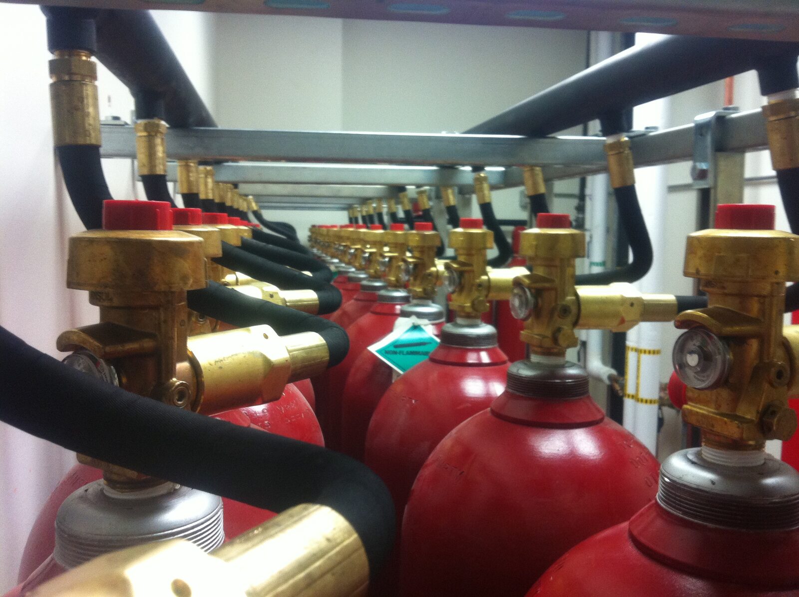 Bank of clean agent cylinders with actuation manifold